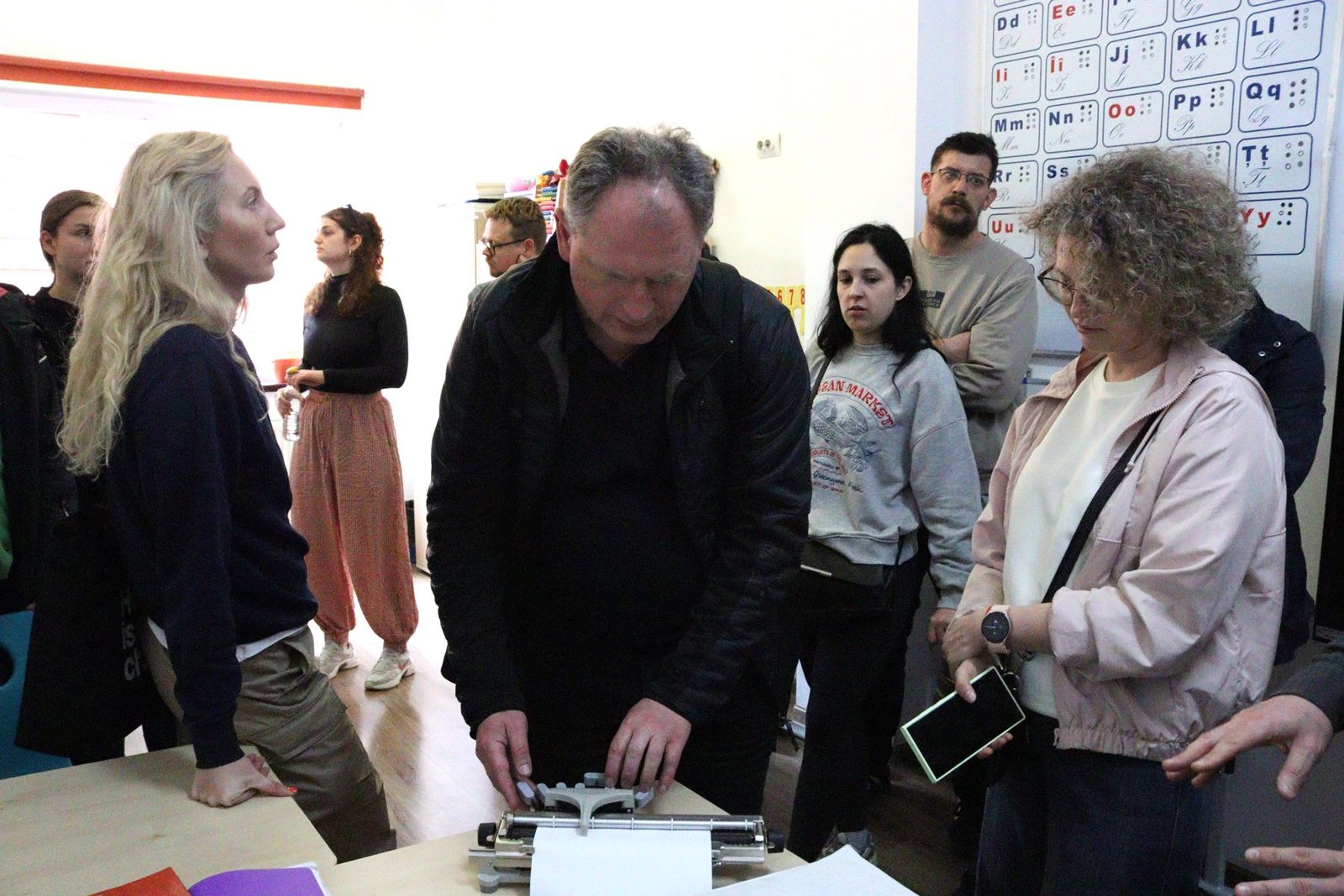 A participant tries a Braille typewriter during the visit to the special high school.