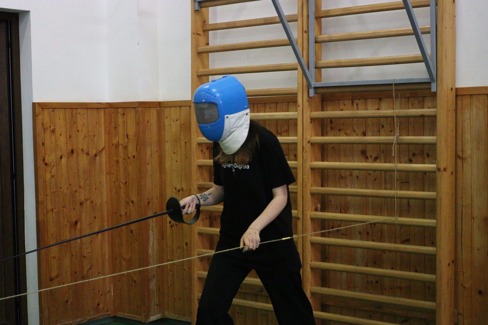 A participant lunges with a foil during a para-fencing session.