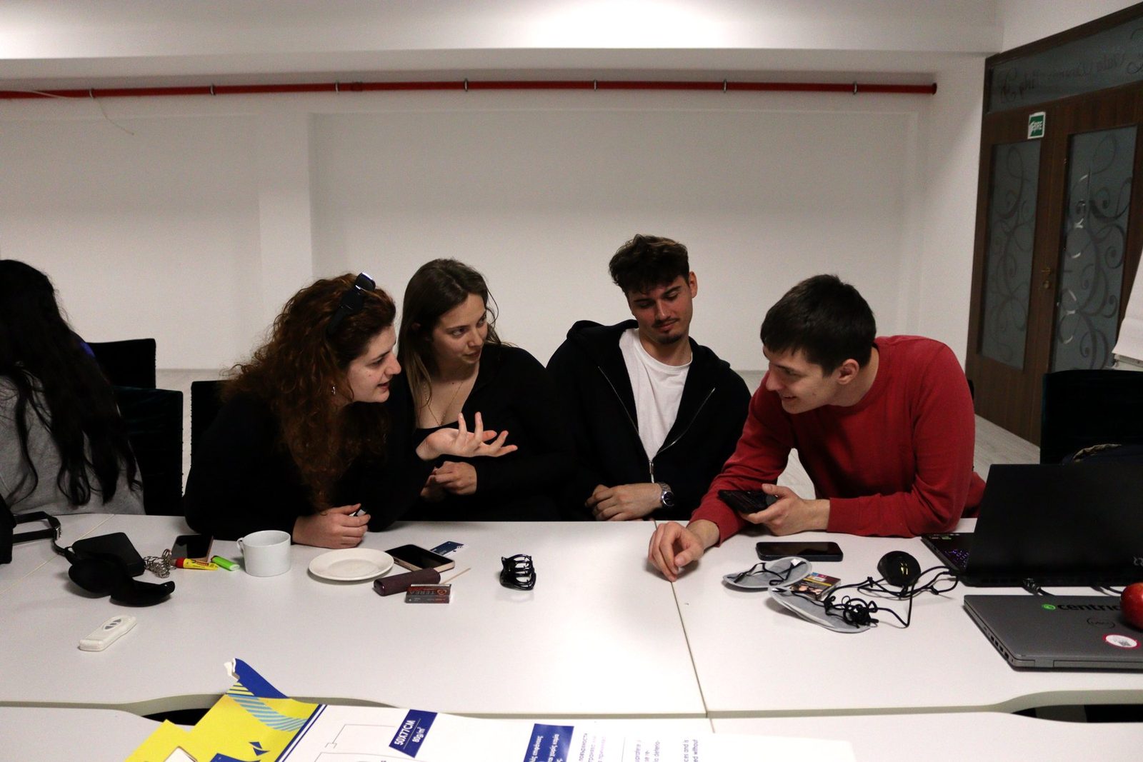 A team plans their short film around a table with audio gear.